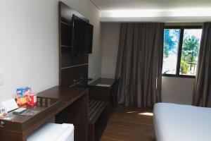 恩卡纳西翁阿瓦度假酒店的配有一张床、一张书桌和一扇窗户的酒店客房