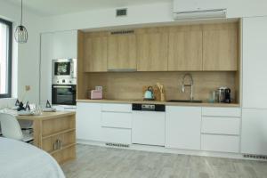 米库洛夫Apartmán X28的厨房配有白色和木质橱柜和书桌。
