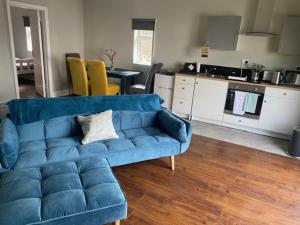 巴利纳Fort Mews的一间带蓝色沙发的客厅和一间厨房