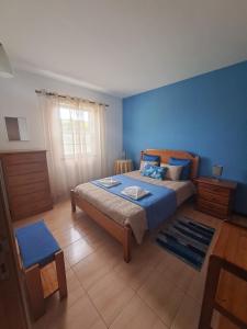Lajes das FloresVila Flor的一间卧室设有一张床和蓝色的墙壁