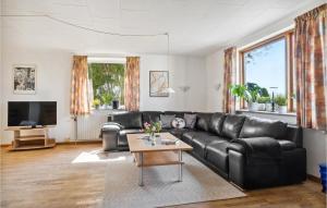 班霍尔姆Lovely Home In Bandholm With Kitchen的客厅配有黑色真皮沙发和桌子
