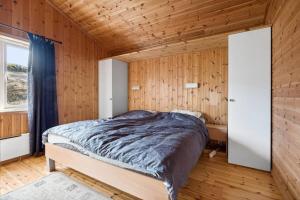 勒丁恩Romslig hytte med natur og gode fiskemuligheter!的卧室配有木墙内的一张床