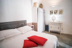 奥斯图尼Casa Le Mura的一张带两个红色枕头的白色床