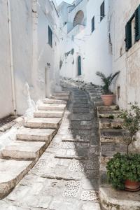 奥斯图尼Casa Le Mura的一条拥有石阶和白色建筑的小巷