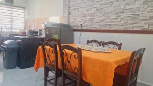 万津Anjung KLIA House 31 With Neflix & Airport Shuttle的用餐室配有带黄桌布的桌子