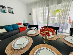 巴亚希贝Beautiful Apartment in Estrella Dominicus Bayahibe的客厅配有带盘子和鲜花的桌子