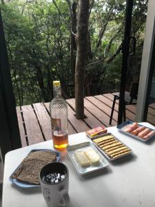 利比里亚Cabaña de montaña espectacular的一张桌子,上面有食物和一瓶酒及饼干