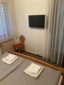 锡默拉特Waldblick的一间卧室设有两张床、一台电视和一把椅子