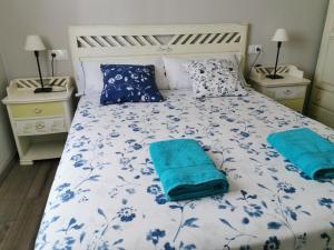 Cangas de FozSan Pedro的一张带蓝色和白色床单及蓝色枕头的床