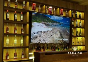 特鲁希略Hoteles Paraiso TRUJILLO的一瓶葡萄酒和电视