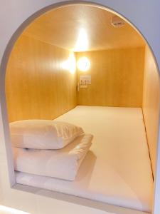 札幌シティキャビンすすきの的带拱形窗户的床的客房