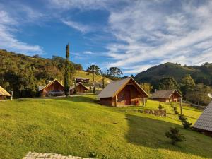 蒙特韦尔迪Pousada Vista do Paraíso的山地绿色田野的房子