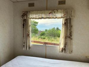 哈日科维Domek za świerkami的一间卧室设有一张床和一个美景窗户。