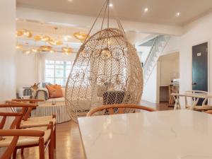 欧申格罗夫Beachliner Hotel的一间设有白色桌椅和大吊灯的客房