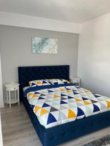 古拉哈莫卢洛伊Apartament - Housing21的一间卧室配有蓝色的床和色彩缤纷的被子