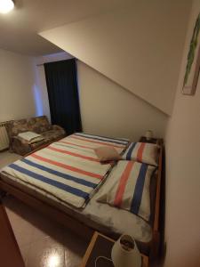 FuškulinApartments Erenda的一间卧室配有带条纹毯子的床
