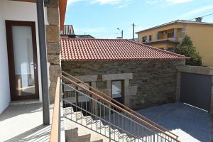 维拉·雷阿尔Casa de Trás-o-Muro的房屋的阳台,设有门和楼梯