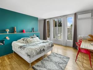 塔桑拉德米吕讷Aux Tourelles 1888 - tres proche Lyon的一间卧室设有蓝色的墙壁和一张床