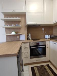 布尔加斯Кай Apartment's Sarafovo的厨房配有白色橱柜和炉灶烤箱。