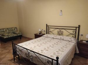 卡斯特姆苏Il Colombaiolo的一间卧室配有一张床、一张沙发和一把椅子