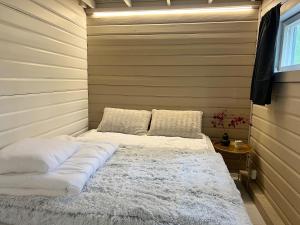 于韦斯屈莱Lake Cottage with sauna (near City)的一间卧室配有带白色床单和枕头的床。