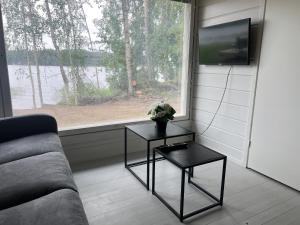 于韦斯屈莱Lake Cottage with sauna (near City)的客厅配有沙发、两张桌子和一扇窗户