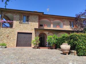 卡斯特姆苏Il Colombaiolo的一座大型石头房子,设有车库和庭院
