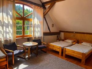 奇强卡Agro - Dom Wsrod Lasow的客房设有两张床、一张桌子和一扇窗户。