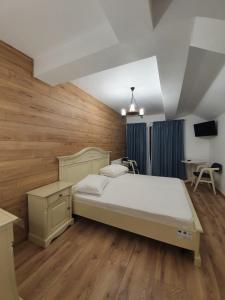 克利默内什蒂Pensiunea Iasmina si Pescarul的一间卧室设有一张大床,铺有木地板。