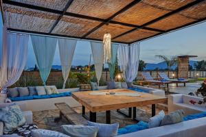 卡拉马孔Villa Arianna, close to the beach!的庭院配有木桌和沙发。