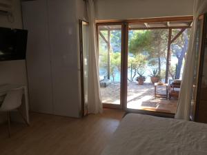 日列岛Apartment by the sea Žirje with private heated hydromassage pool的一间卧室设有一张床和一个滑动玻璃门