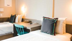 圣利奥波尔杜Work Hotel São Leopoldo的酒店客房配有书桌、床和桌子。