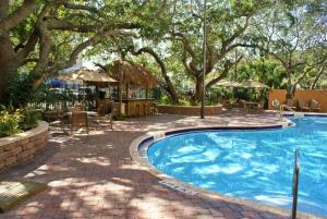 可可比奇Courtyard by Marriott Cocoa Beach Cape Canaveral的一个带庭院和树木的游泳池