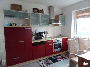 布伦Ferienwohnung Büren-Harth的厨房配有红色橱柜和红色炉灶