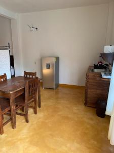 埃斯孔迪多港Casa Suites Minizoo的厨房配有桌子和不锈钢冰箱。