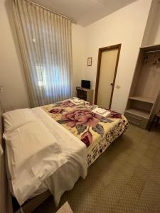 斯培西亚奥罗拉酒店的一间设有一张床铺的卧室,位于一个带镜子的房间