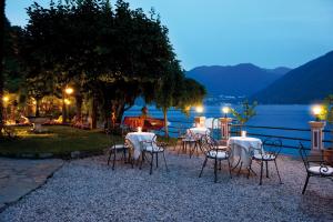 瓦尔索达斯特拉'意大利酒店的一群桌子和椅子在晚上靠近水边