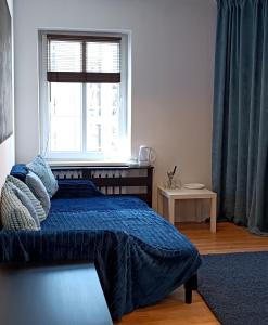 华沙Duży prywatny pokój blisko Starego Miasta. Pokój 7的一间卧室配有一张带蓝色棉被的床和窗户。