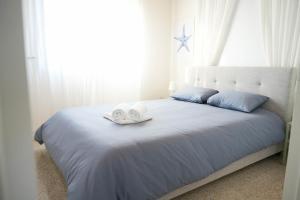 梅内乌Ocean Blue House 17的一间卧室配有一张床,上面有两条毛巾