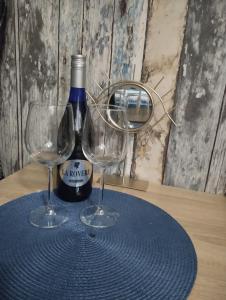 普里耶多尔Apartman (stan na dan) M&M 2 Prijedor的桌子上放有一瓶葡萄酒和两杯酒