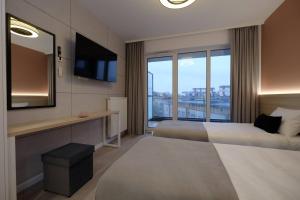 比亚韦斯托克Apartamenty Centrum的酒店客房设有两张床和电视。