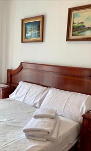 比利亚努埃瓦-赫尔特鲁Villa Felicidad的卧室配有一张墙上有两张照片的床。