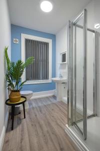 布莱克浦Bank Street Apartment 7的一间带淋浴的浴室和客房内的植物