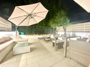 特罗佩阿Mottola Apartment的一个带桌子和遮阳伞的庭院