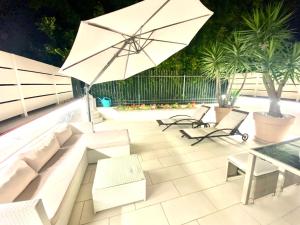 特罗佩阿Mottola Apartment的一个带沙发和遮阳伞的庭院