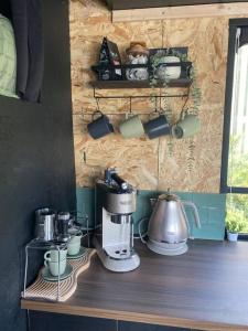 索兹Horse Truck Tiny Home的厨房柜台配有咖啡壶和杯子