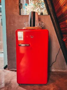 圣若热岛Sítio Aroeira Cabanas的旧红色冰箱,坐在墙上