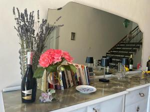 Montalto delle MarcheLa Filanda的一张桌子,上面放着一瓶葡萄酒和花瓶