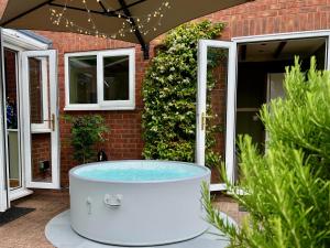 Churchdown4-bed Cotswold getaway with hot tub & gaming room的热水浴池位于房子外