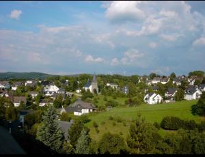 奥尔珀Ferienwohnung & Zimmer的山丘上一座拥有房屋和教堂的小城镇